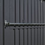 Locking bar to secure a hatch on a flatpack kiosk